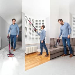 Aspiradora escoba Shark IZ251 2 en 1 Burdeos Sin Cable 45V 80min, en uso: hombre aspira moqueta, persiana y sofá