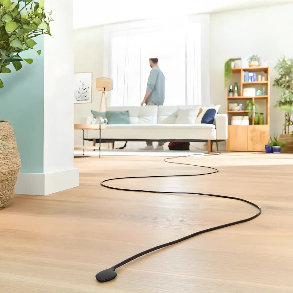 Aspirateur avec sac Bosch Série 4 Rouge 600W BGD38RD1H, en utilisation: câble noir étendu sur parquet avec personne aspirant