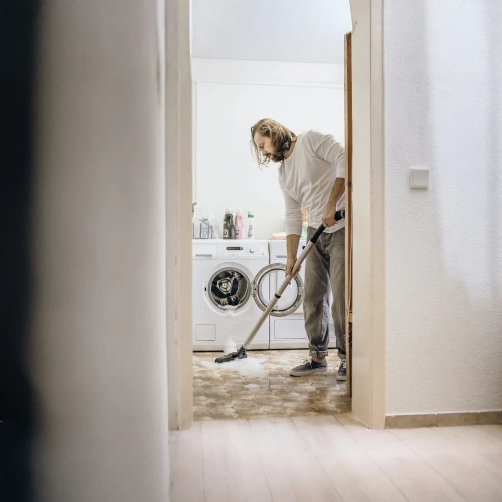 Aspirador sólidos y líquidos Kärcher WD 6 Premium P S 1300W V-30/6/22/T, en uso: hombre aspira agua del suelo en cuarto