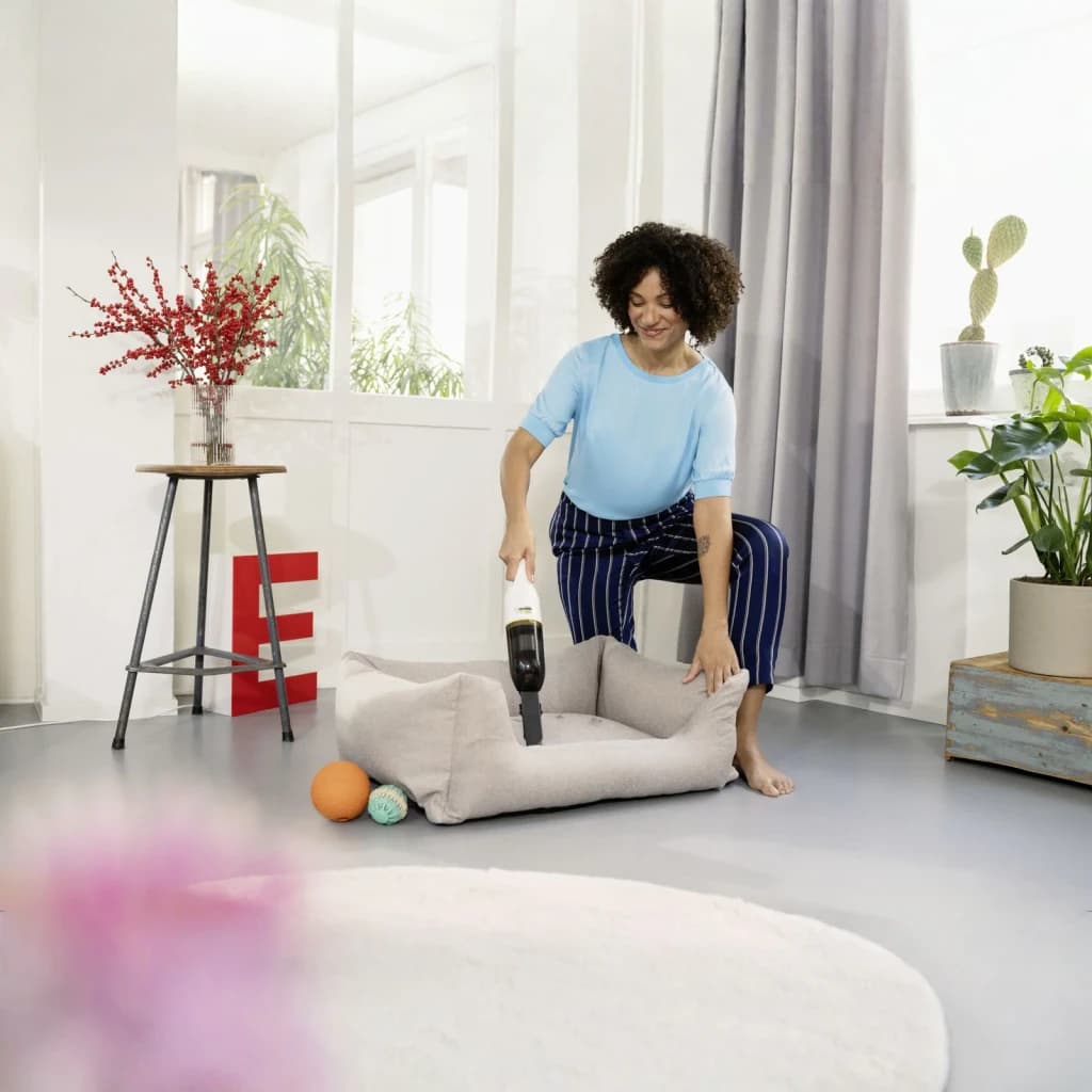 Aspiradora de mano Kärcher CVH 2 Negro/Blanco Sin Cable 7,2V Li-Ion 20min, en uso: mujer aspira cama de mascota en salón