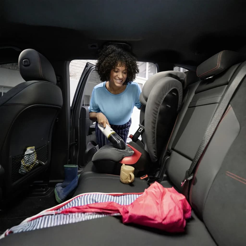 Aspiradora de mano Kärcher CVH 2 Negro/Blanco Sin Cable 7,2V Li-Ion 20min, en uso: mujer aspira asiento trasero de coche
