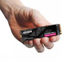 SSD Kioxia Exceria PRO G2 1TB NVMe PCIe Gen5 M.2 2280 Negro, en uso: mano sosteniendo el SSD con disipador negro y etiqueta
