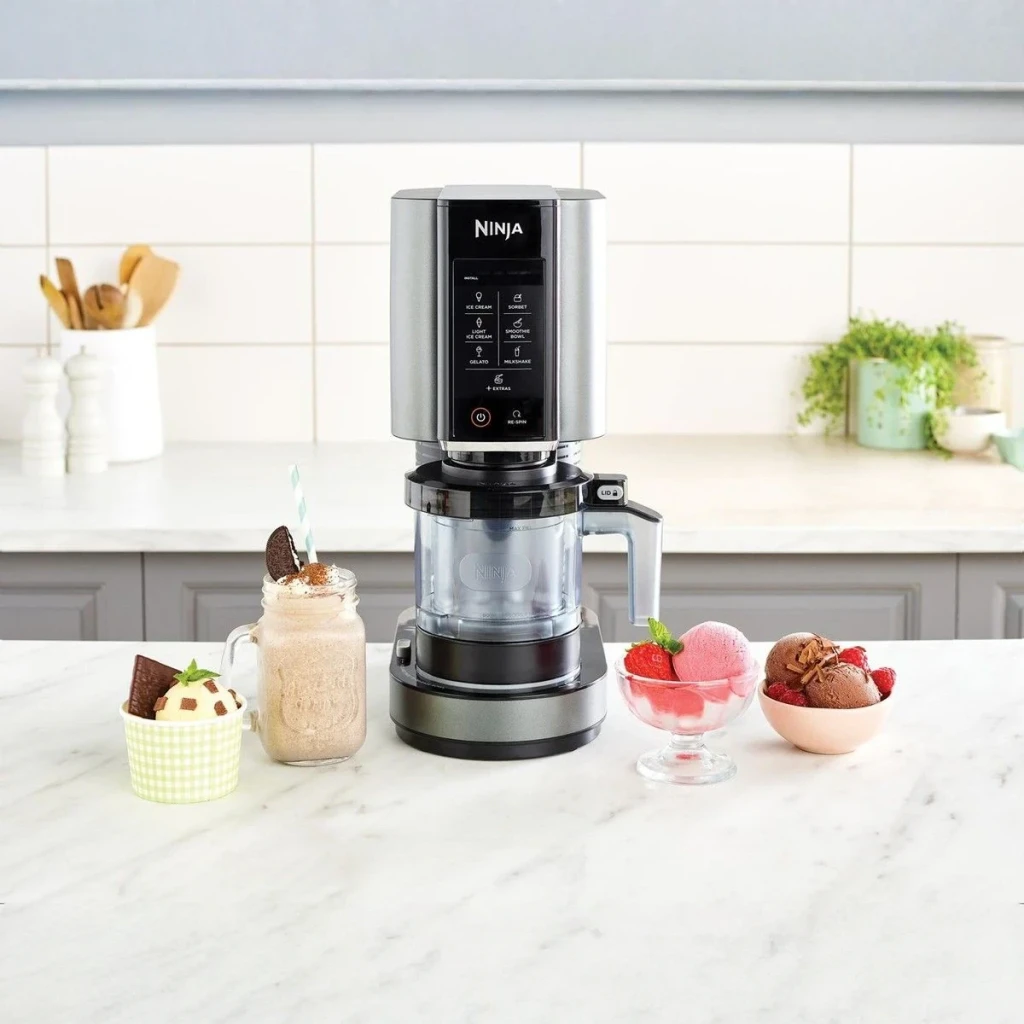 Sorbetière Ninja CREAMi 1,4L 800W Noir/Argent NC300EU, vue lifestyle: panneau tactile et bol transparent entourés de glaces