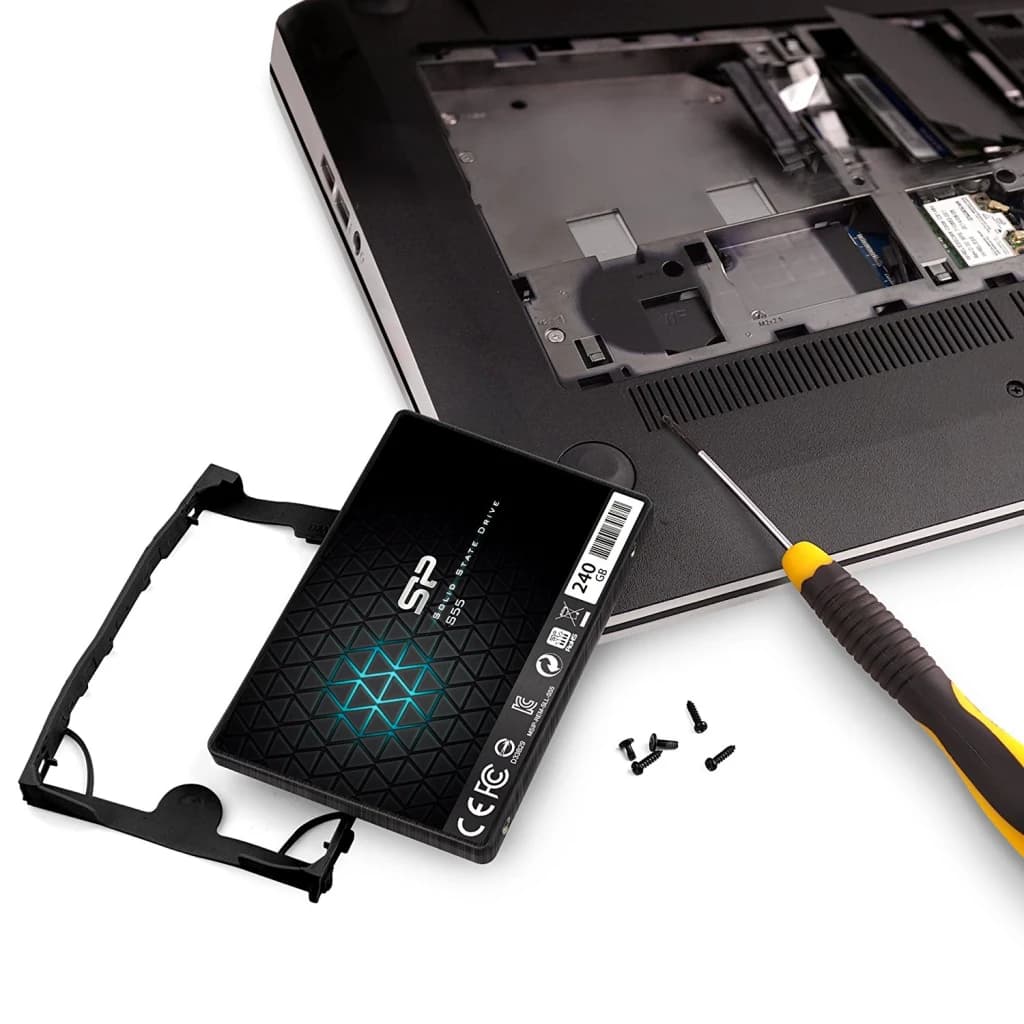 SSD Silicon Power Slim S55 240 Go 2.5 pouces SATA Noir, installation: unité avec support près d'un laptop ouvert et tournevis