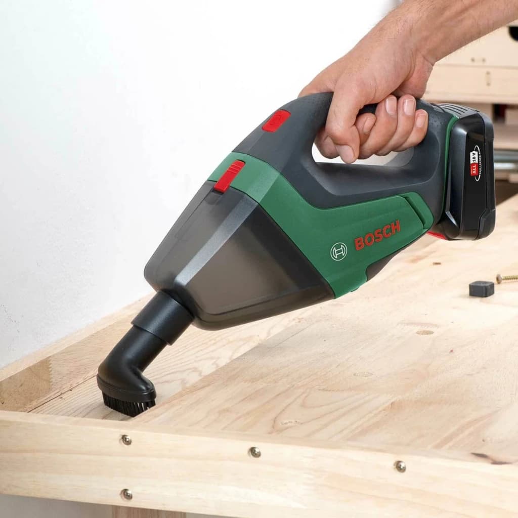 Aspirateur à main Bosch UniversalVac 18 Noir/Vert Sans Fil Sans batterie, en action: main tenant l'appareil aspirant