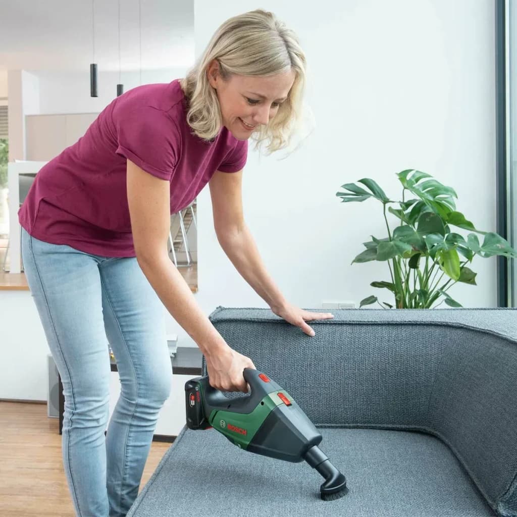 Aspirateur à main Bosch UniversalVac 18 Noir/Vert Sans Fil Sans batterie, usage: femme aspire canapé gris avec brosse