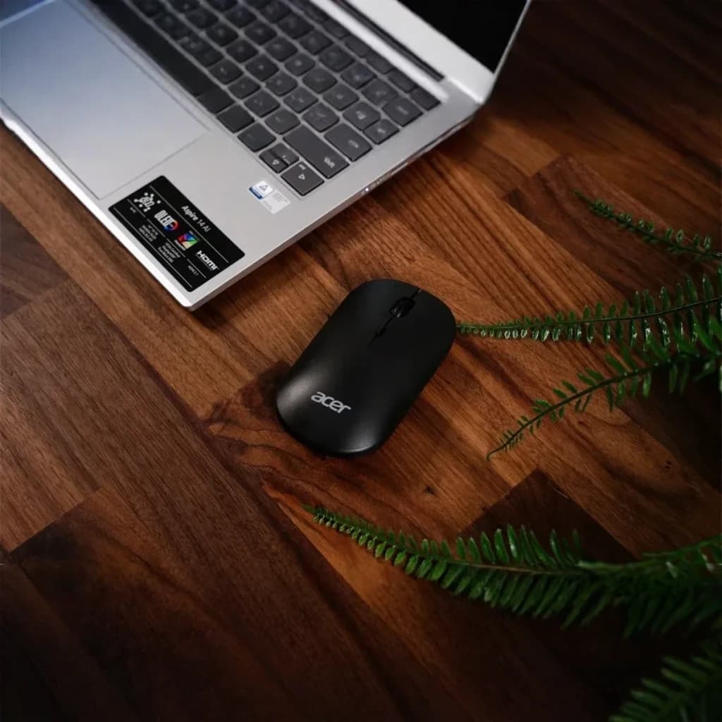 Souris Acer AMR130 Noir Sans Fil Dual Mode, vue de dessus: sur bureau en bois avec laptop Acer et plante verte