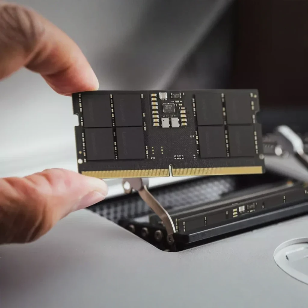 Memória RAM GoodRam DDR5 5600MHz CL46 SO-DIMM 32GB 1x32GB Preto GR5600S564L46/32G, instalação: mãos inserindo módulo preto