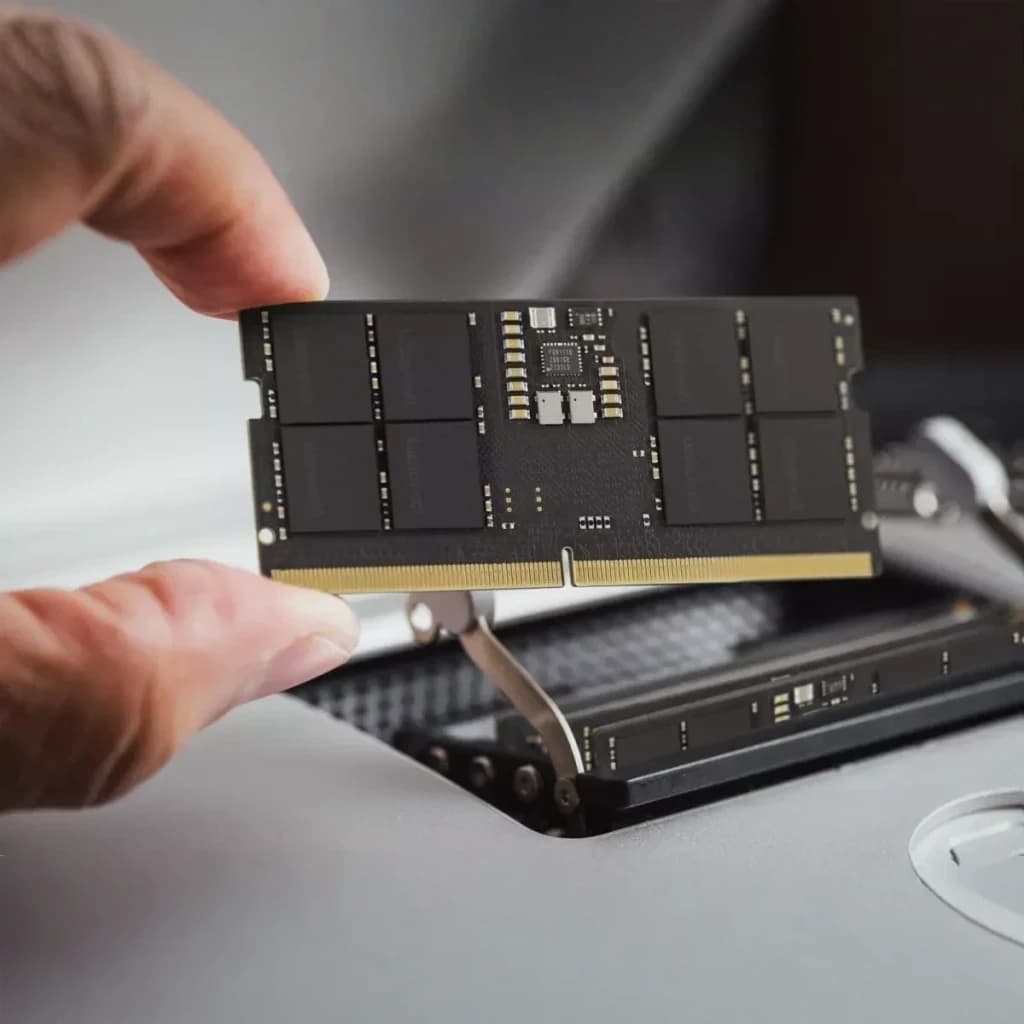 Memória RAM GoodRam DDR5 5600MHz CL46 SO-DIMM 32GB 1x32GB Preto GR5600S564L46/32G, instalação: mãos inserindo módulo preto