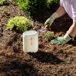 Enceinte portable Ultimate Ears Epicboom IP67 17h Bluetooth Blanc, en utilisation: posée sur terre humide au jardin