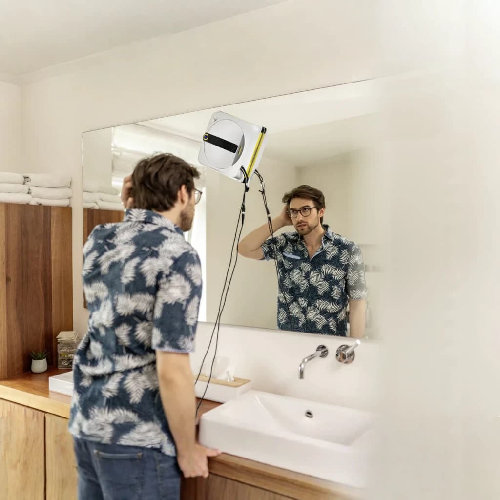 Robot limpiacristales Kärcher RCW 4 Extra 5000Pa 77dB en uso: hombre observa el robot limpiando espejo de baño