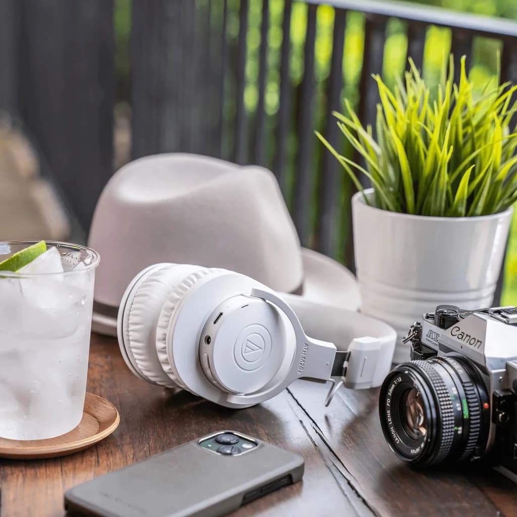 Casque Audio-Technica ATH-M20xBT Supra-auriculaire Bluetooth 5.0 60h Blanc, en utilisation: posé sur table en bois