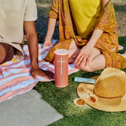 Enceinte portable Ultimate Ears Megaboom 4 IP67 20h Bluetooth Rouge, en utilisation: sur herbe en pique-nique près d'un