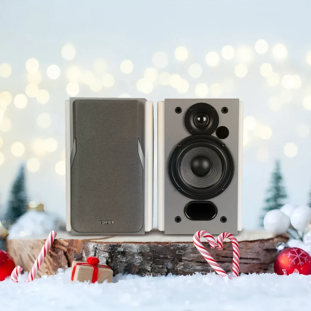 Enceintes Edifier 42W Bluetooth 5.1 Blanc R1380DB, en situation: paire sur bûche enneigée, une avec grille et une