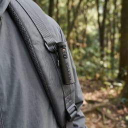 Linterna LED Flextail Zero 1200 Negra Recargable USB-C IP67, en uso: sujeta a la correa de mochila en bosque