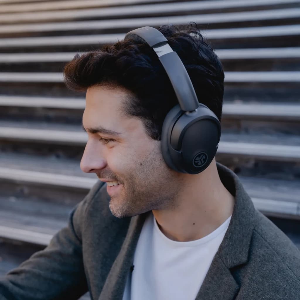 Auriculares JLab Audio IEUHBJLUXANCRGPH62 Cancelación de Ruido Diadema, uso: hombre de perfil sonriendo con auriculares