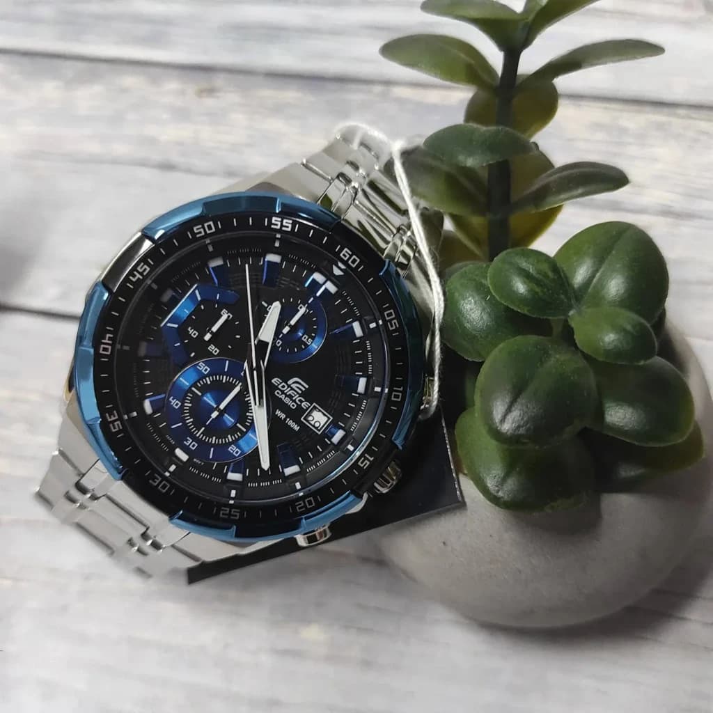 Casio Edifice EFR-539D-1A2VUEF Argent Noir Batterie 2 Ans 10ATM, en situation: montre sur surface en bois avec plante