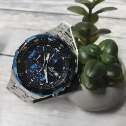 Casio Edifice EFR-539D-1A2VUEF Argent Noir Batterie 2 Ans 10ATM, en situation: montre sur surface en bois avec plante