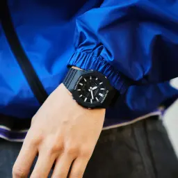 Casio G-Shock GA-2100-1AER Noir Chronomètre, Heure Mondiale 29 fuseaux 20ATM, au poignet: boîtier octogonal noir sur veste