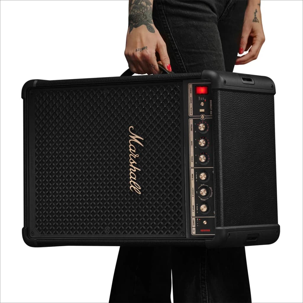 Coluna Portátil Marshall PARTY S.BROMLEY450 IP55 40h Bluetooth 5.3 Auracast, em uso: pessoa tatuada segura a coluna preta