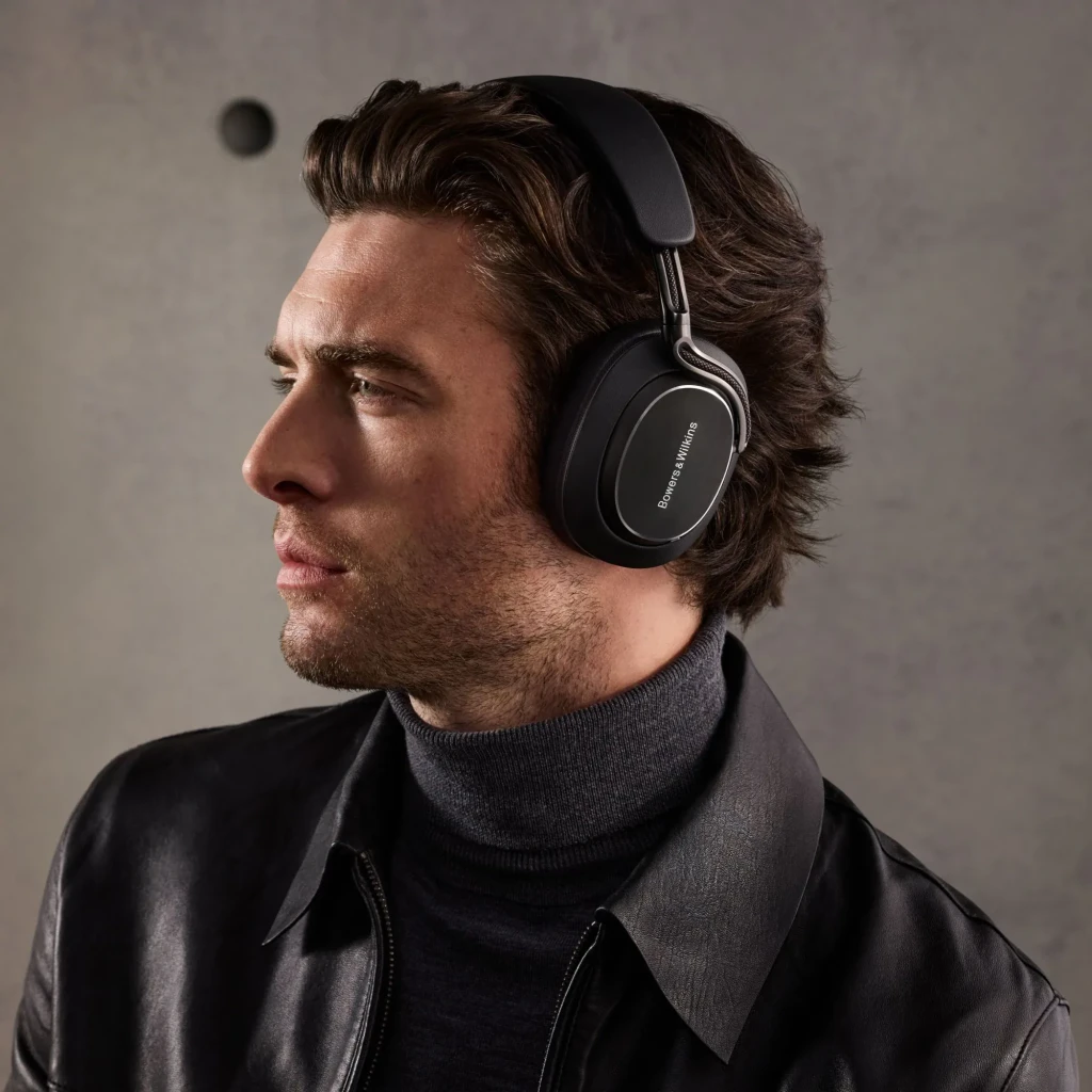 Auscultadores de banda Bowers & Wilkins Px8 S2 Cancelamento de Ruído Híbrido Preto, em uso: homem de perfil com casaco