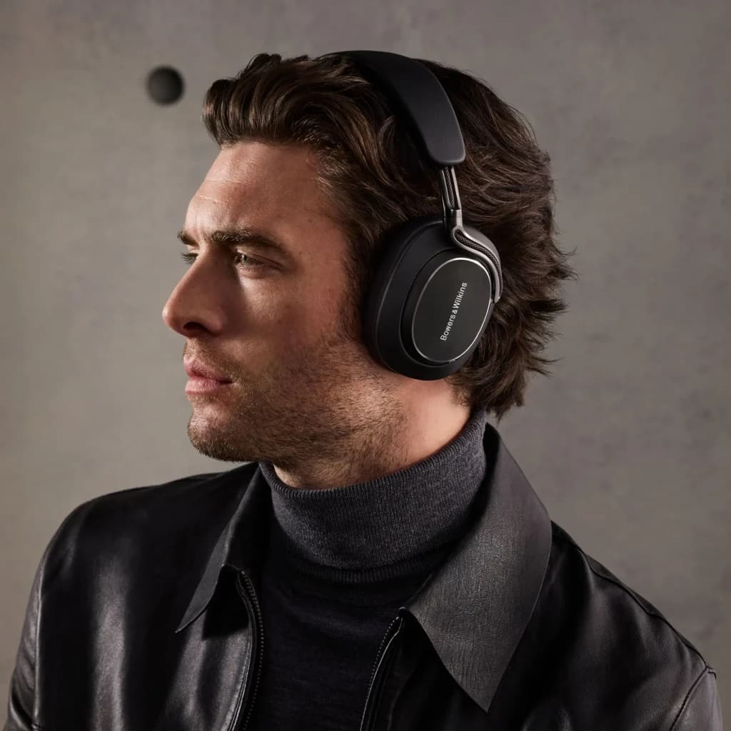 Auscultadores de banda Bowers & Wilkins Px8 S2 Cancelamento de Ruído Híbrido Preto, em uso: homem de perfil com casaco
