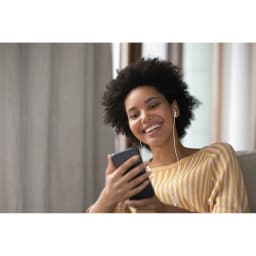 Écouteurs JVC HA-FR17UC Intra-auriculaires USB-C IPX2 Blanc, usage: femme souriante sur canapé écoutant musique via
