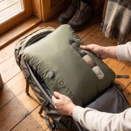 Sac de compression Flextail EZYPACK 25L Vert Nylon 70D TPU imperméable 35×50×11 cm, en utilisation: mains l'insérant rempli