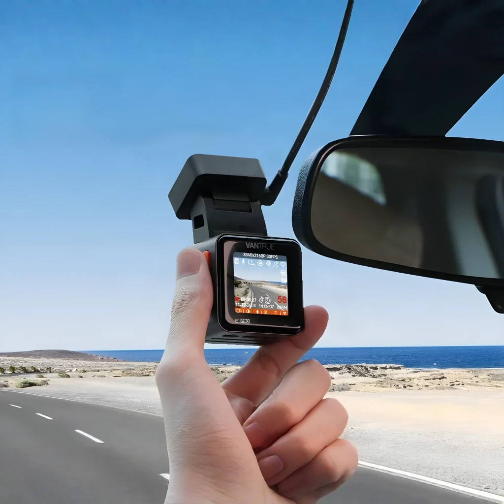 Dashcam Vantrue E1 Pro 1 Canal 4K HDR GPS, en utilisation: main tenant la caméra avec écran actif affichant données GPS