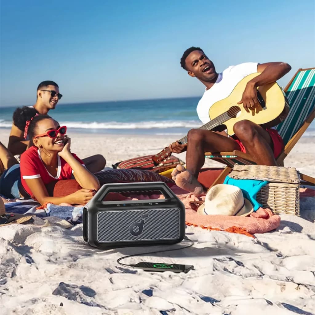 Altavoz portátil Anker Soundcore Boom 2 SE IPX7 30W 18h Negro, en uso: sobre arena de playa con grupo de amigos
