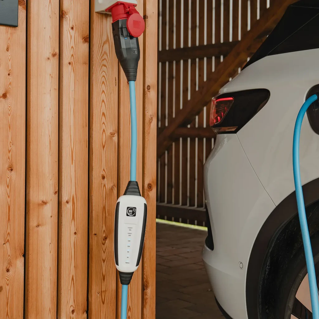 Carregador Portátil EV NRGkick Set Optimal 11 kW 16A 5m Wi-Fi Branco Tipo 2, em uso: unidade branca pendurada em parede