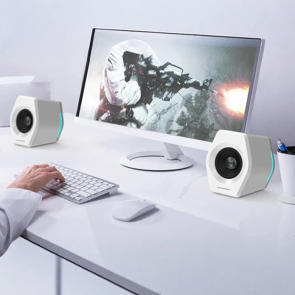 Altavoces Edifier G2000 32W Bluetooth blancos, en uso: par flanqueando monitor gaming con iluminación RGB azul
