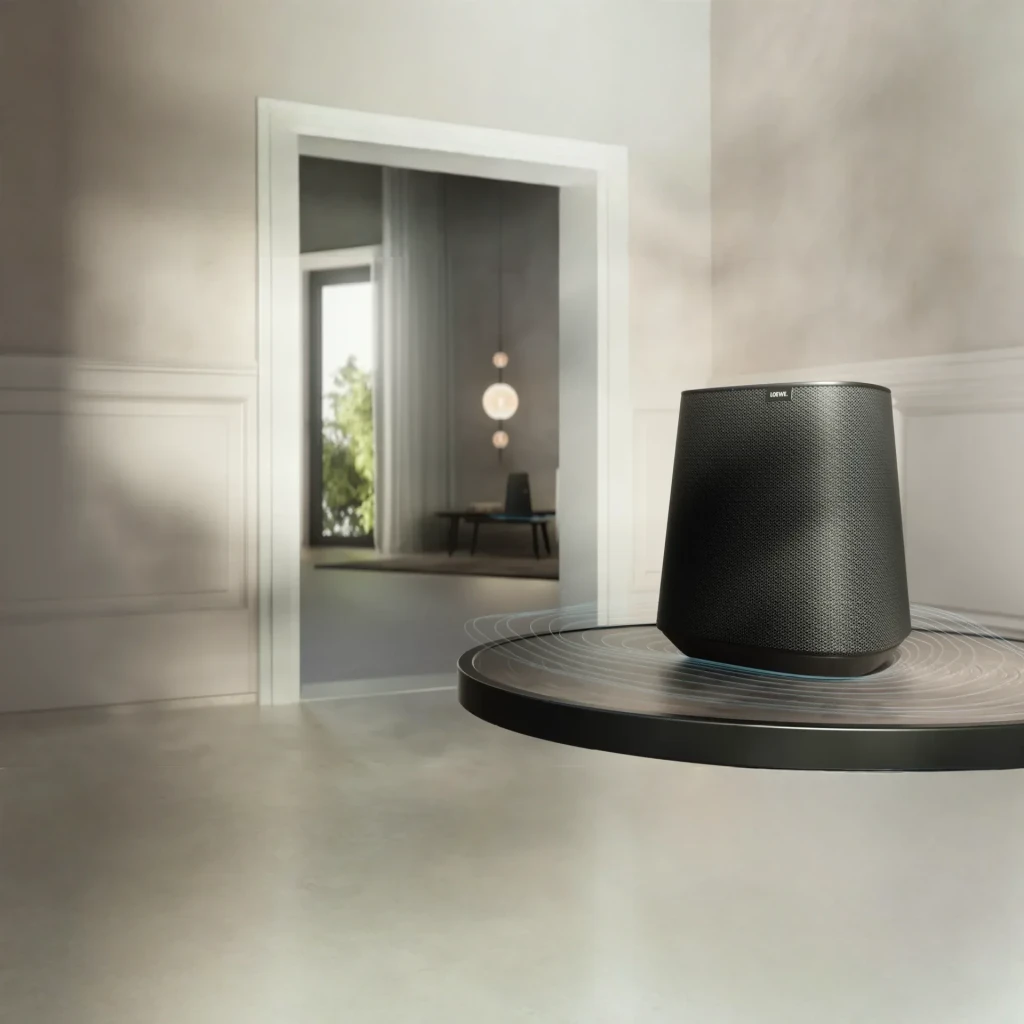 Altavoz Multiroom Loewe Klang MR1 30W WiFi Doble Banda, Bluetooth Gris, en uso: sobre mesa redonda negra con ondas