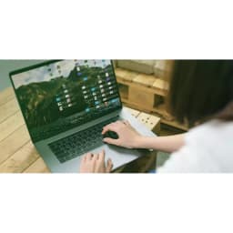 SSD Western Digital Green SN350 250GB M.2 NVMe PCIe 3.0, uso: mujer trabajando en portátil con escritorio lleno de archivos
