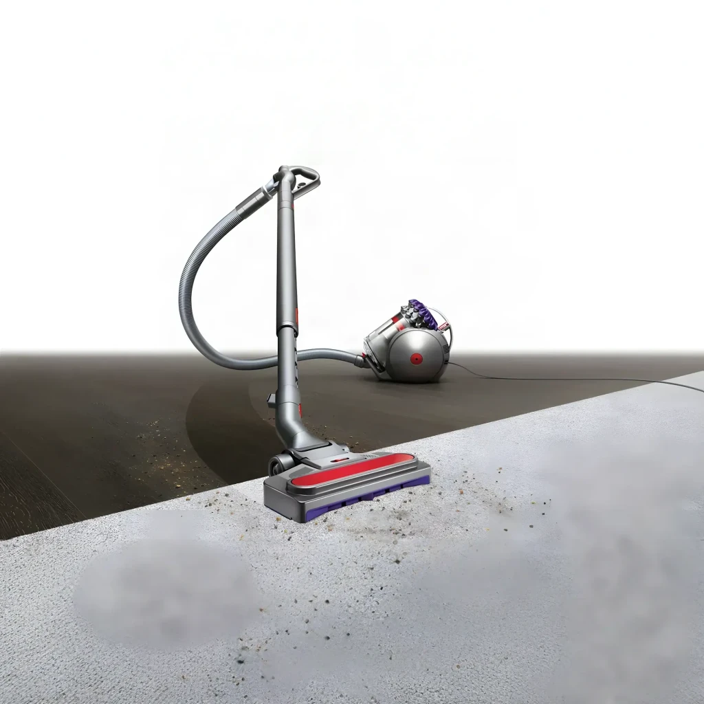 Aspiradora Dyson Big Ball Absolute 2, en uso: boquilla sobre suelo gris aspirando suciedad, cuerpo esférico al fondo