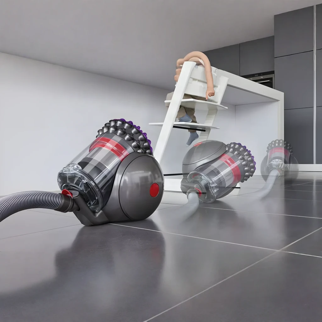 Aspiradora Dyson Big Ball Absolute 2 en uso: cuerpo esférico gris girando en suelo de baldosa gris en cocina moderna