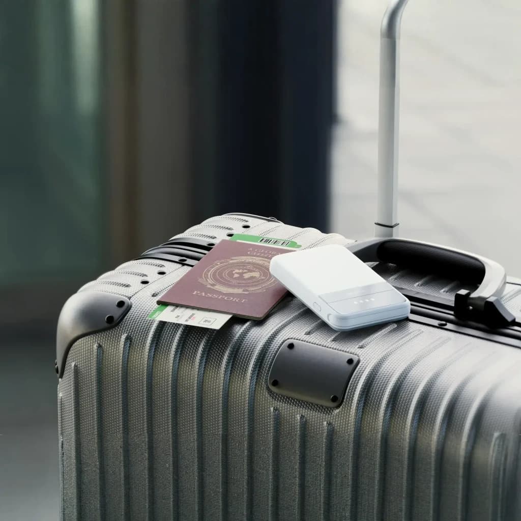 Power Bank EcoFlow RAPID 5000 5000mAh Bleu Qi2 15W Câble USB-C intégré 30W, scène voyage: sur valise grise avec passeport