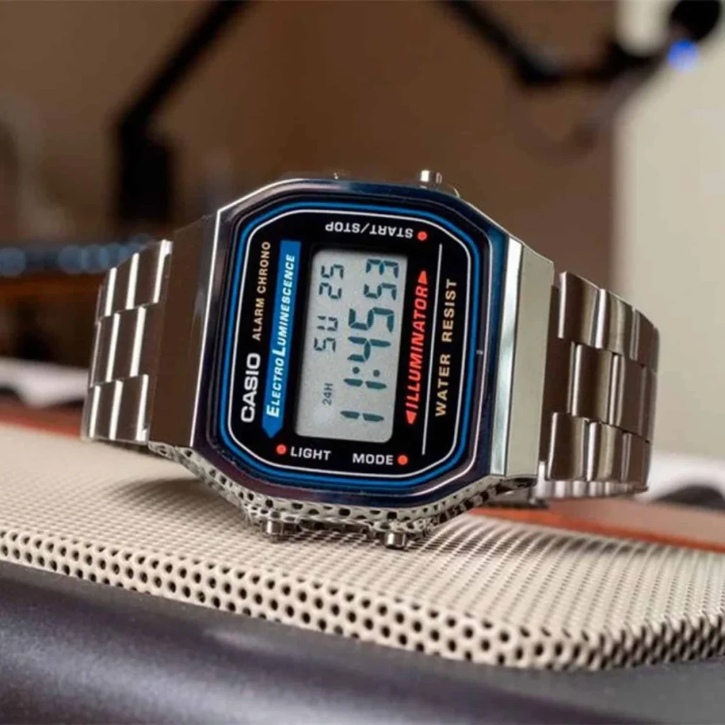 Casio A168WA-1WDF Cronógrafo, Alarme, Calendário Bateria 7 Anos 3ATM, em uso: relógio prateado sobre superfície texturizada