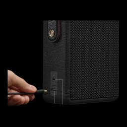 Coluna portátil Marshall Stockwell III IP55 65W 40h Bluetooth 5.3 preta, detalhe: mão a ligar cabo USB-C no painel lateral