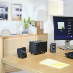 Altavoces Trust Avora 2.1 Subwoofer Activo 9W RMS, en uso: sistema negro sobre escritorio de madera con monitor
