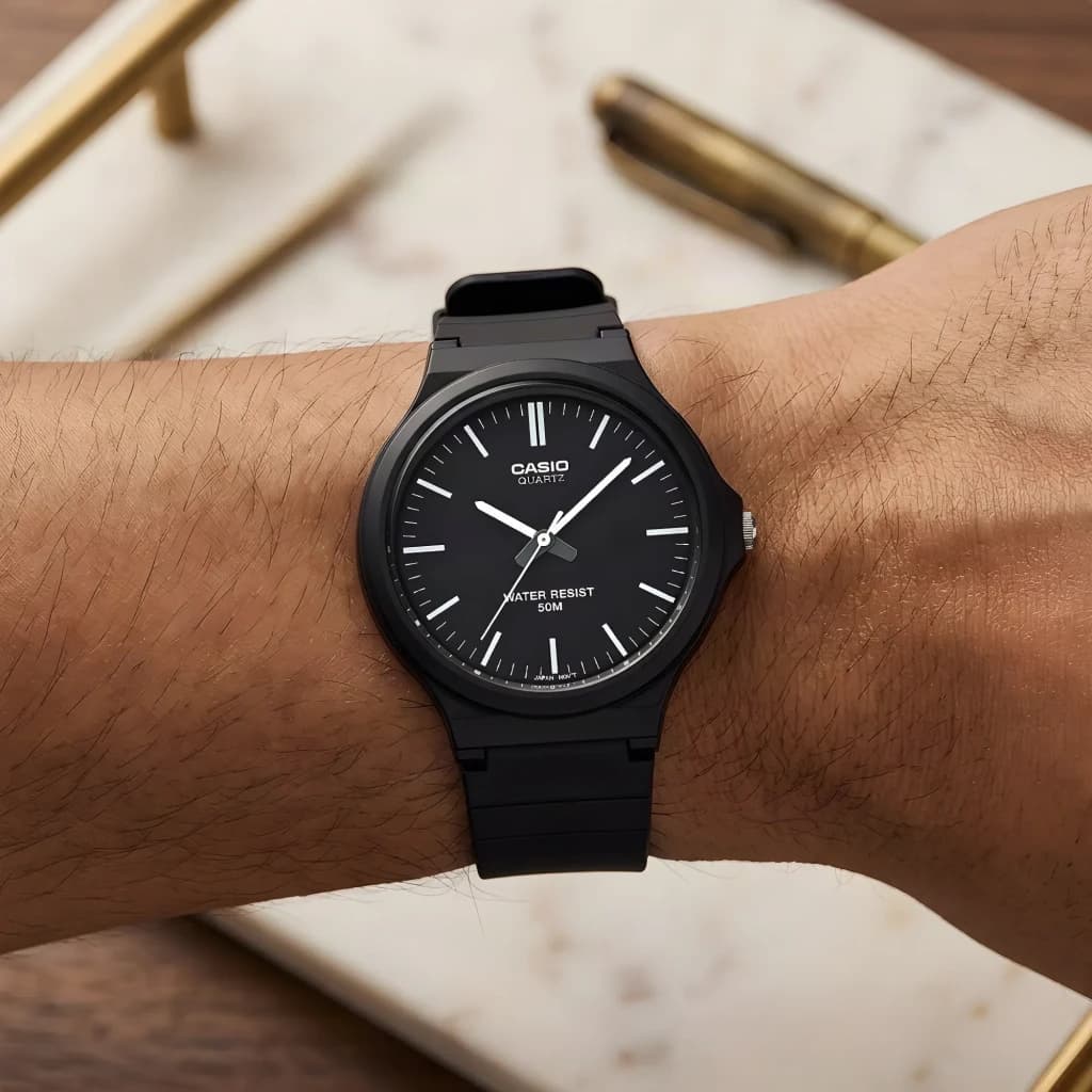 Casio MW-240-1EVDF Batterie 3 Ans 5ATM, en utilisation: montre noire au poignet, cadran noir avec index blancs et texte