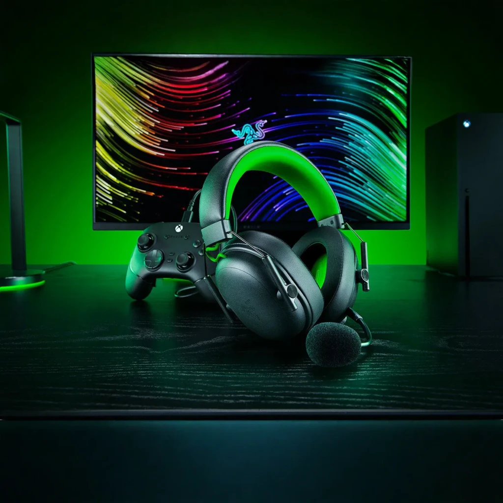 Auriculares Gaming Razer BlackShark V3 X HyperSpeed for Xbox Sem Fios, em uso: sobre secretária escura com comando Xbox