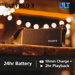 Enceinte portable Sony ULT Field 3 IP67 27W 24h Bluetooth 5.2 noire, en utilisation: posée sur bois avec lumières bokeh