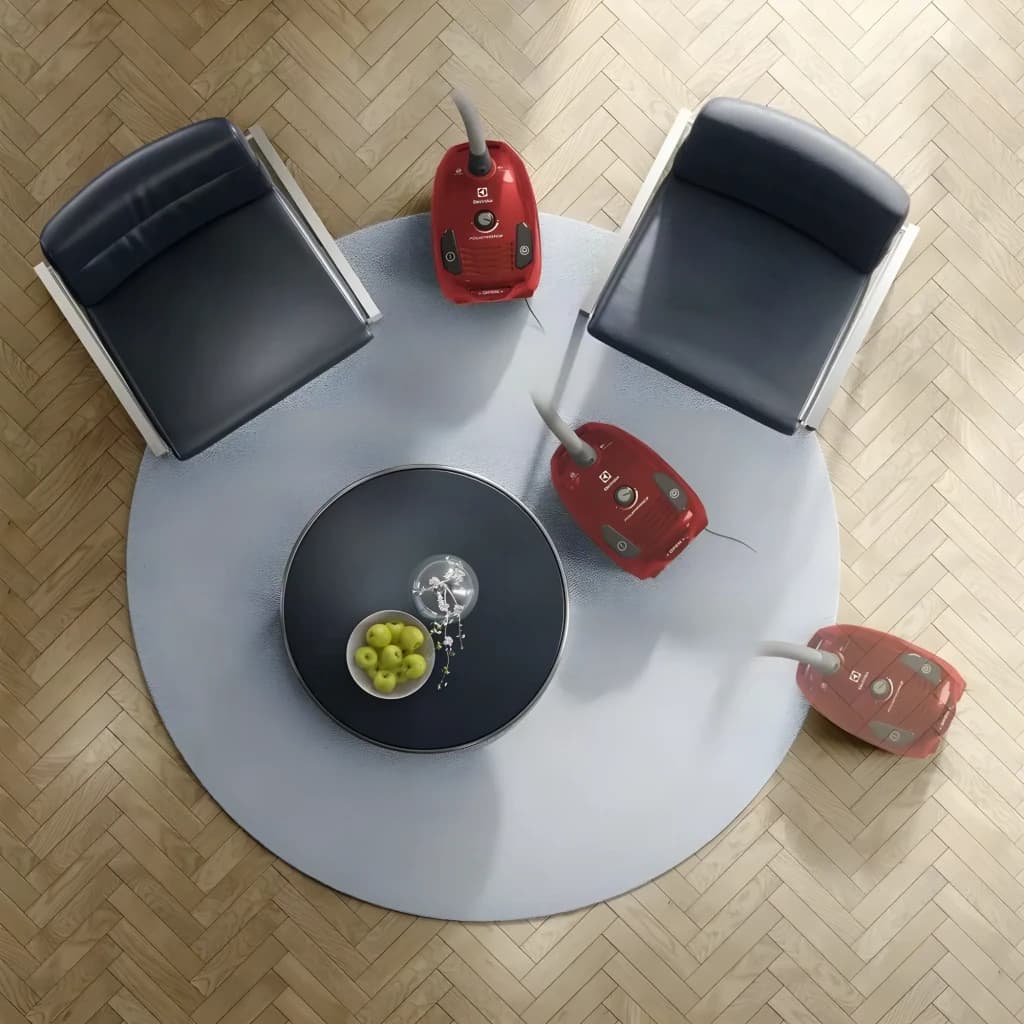 Aspirateur avec sac Electrolux Noir/Rouge 800W EPF61RR, vue aérienne: trois unités sur tapis rond dans salon avec parquet