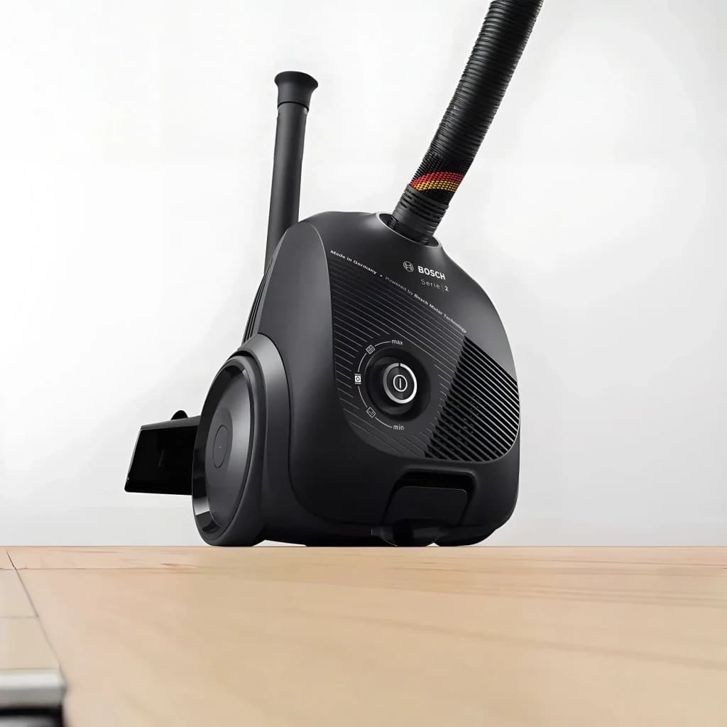 Aspirateur à sac Bosch Série 2 Noir 600W BGDS2CHAMP, en cours d'utilisation: vue latérale basse sur parquet, flexible
