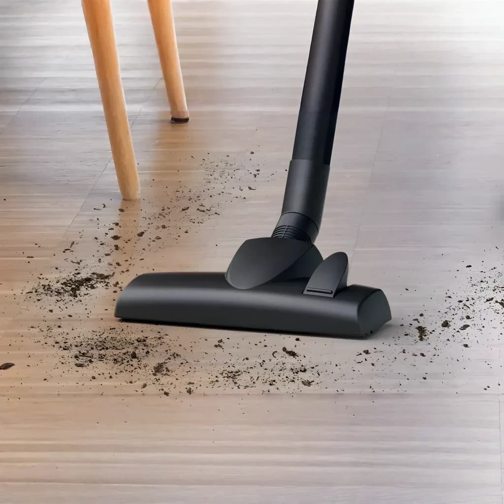 Aspirateur à sac Bosch Série 2 Noir 600W BGDS2CHAMP, en utilisation: suceur noir aspirant des saletés sur parquet stratifié