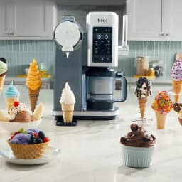 Máquina de Gelados Ninja CREAMi Scoop & Swirl 0,47L 800W Prata NC701EU, vista lifestyle: rodeada de gelados em cones e taças