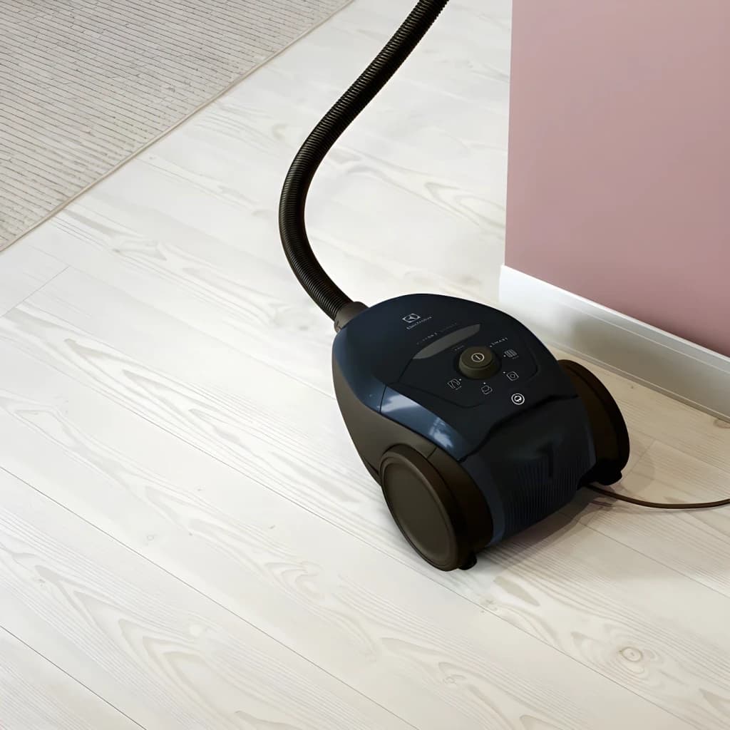 Aspirador cilíndrico Electrolux PD82-4ST Preto 600W, vista em uso: corpo sobre soalho laminado claro com mangueira flexível
