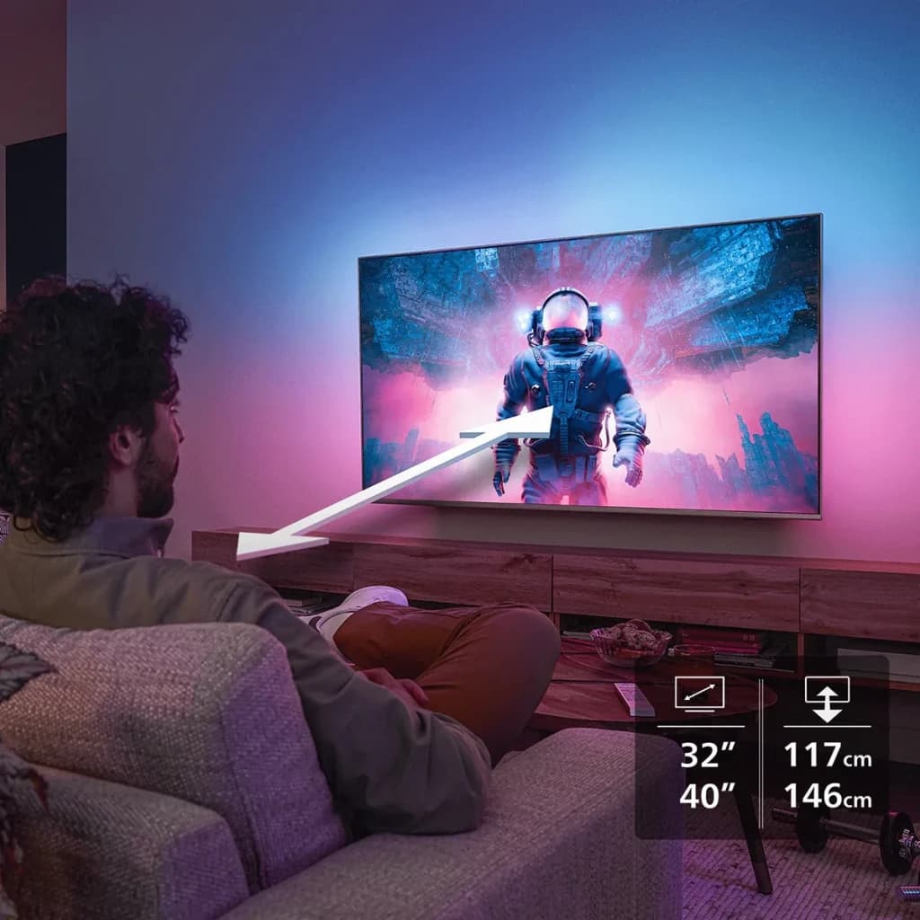 TV Philips 40 pulgadas QLED Full HD Titan OS Negro 40PQS6901/12, en salón: hombre en sofá viendo astronauta en pantalla