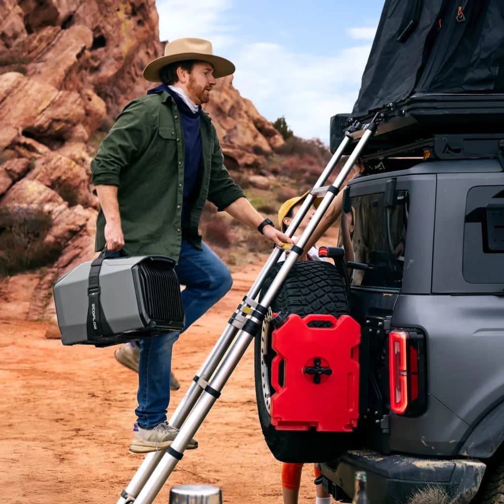 Sangle de transport EcoFlow à Velcro WAVE 3 Noir, en utilisation: homme porte le climatiseur par la sangle noire près d'un